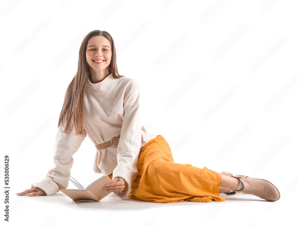 Beautiful woman with book sitting on white background