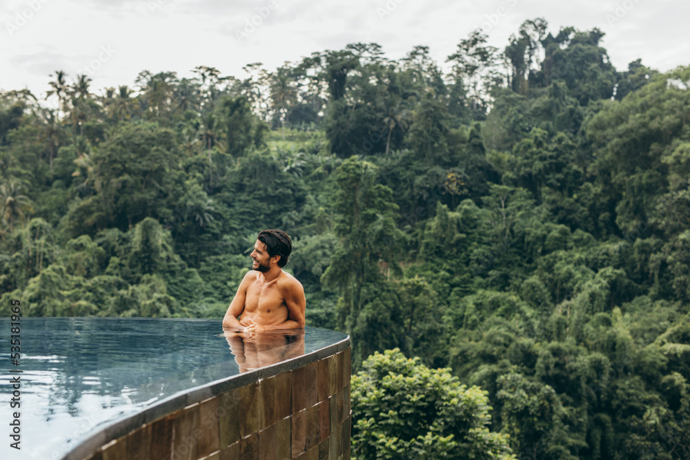 Man standing in a swimming pool and looking away