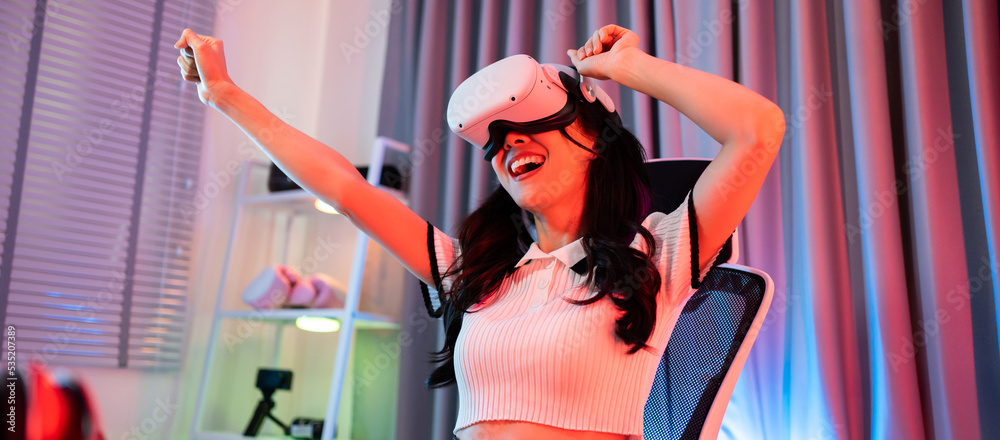 Asian young esport woman gamer use technology VR glasses and play game