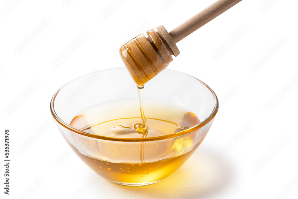 Honey and honey dippers in glass bowls on white background.