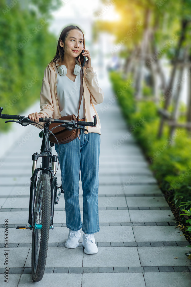 美丽的亚洲女人用手机耳机听最喜欢的音乐，幸福放松