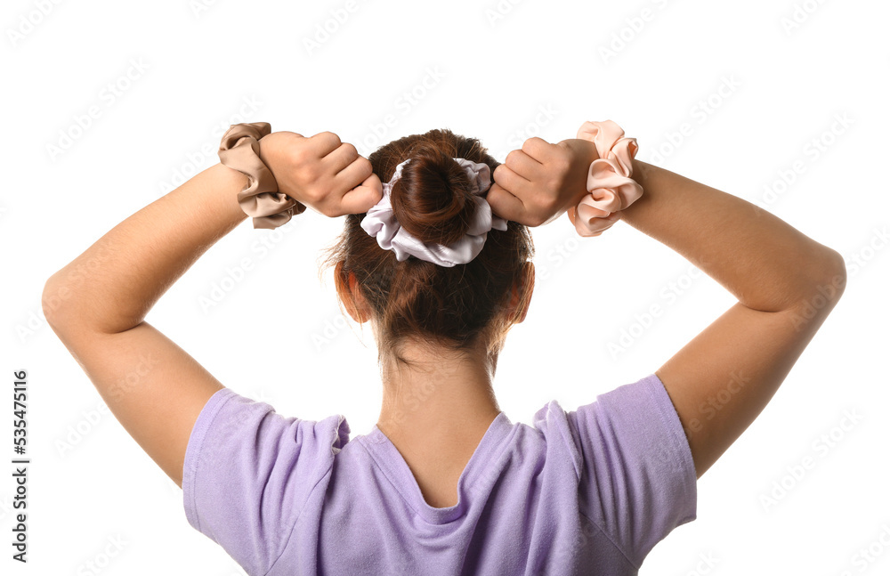 Woman with bun hairstyle and different silk scrunchies on white background