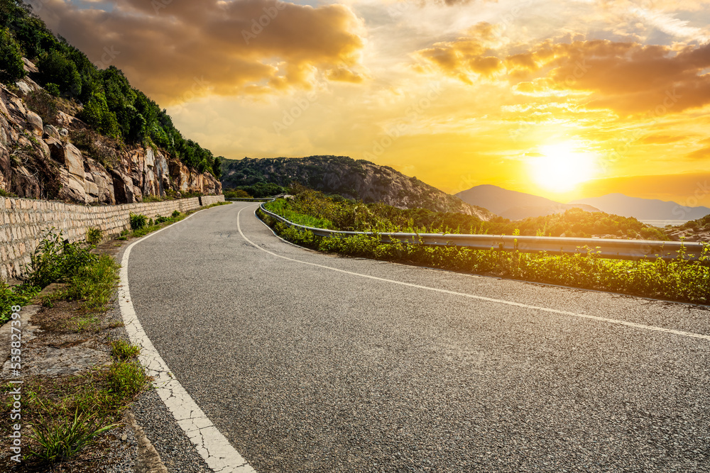 Asphalt road and mountain with sky clouds natural scenery at sunset