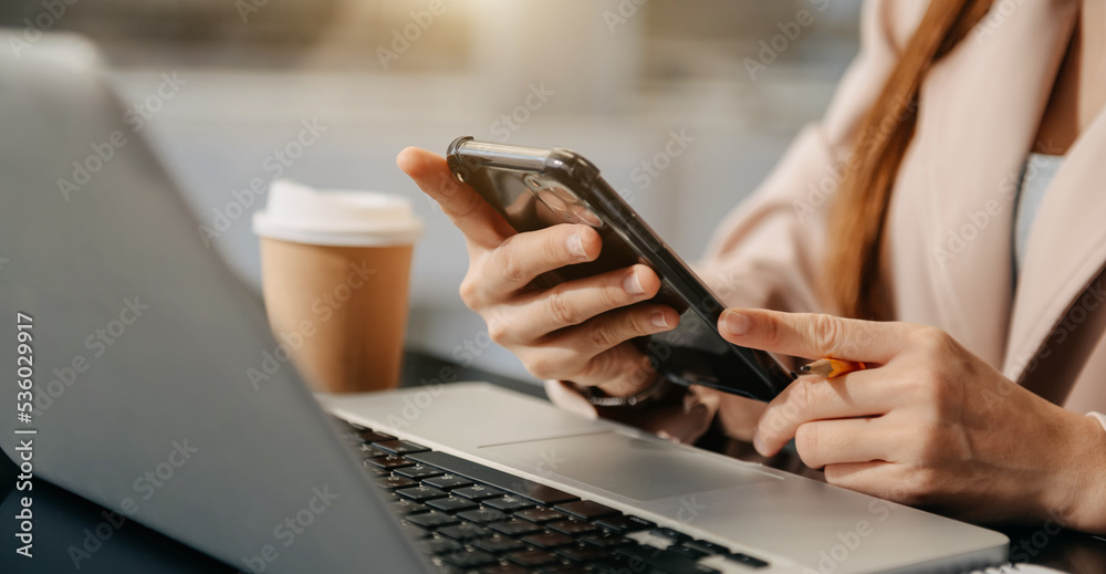 Woman using smart phone for mobile payments online shopping,omni channel,sitting on table, graphics 