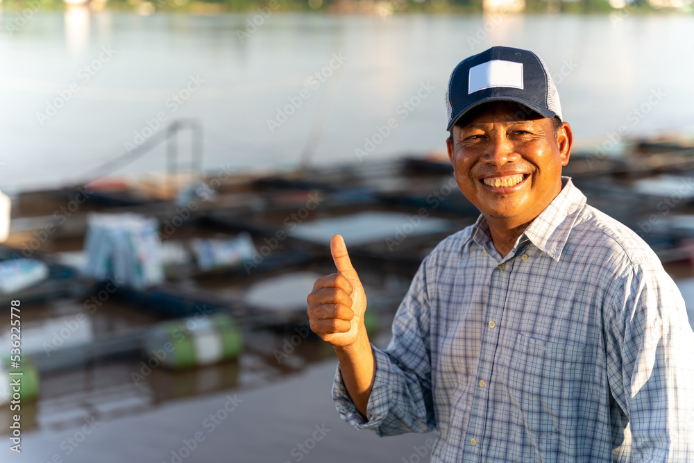 亚洲快乐的水产养殖农民在池塘和笼子里。罗非鱼养殖。罗非鱼。