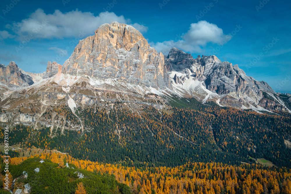 Autumn colorful larch forest and high mountains in background, Dolomites