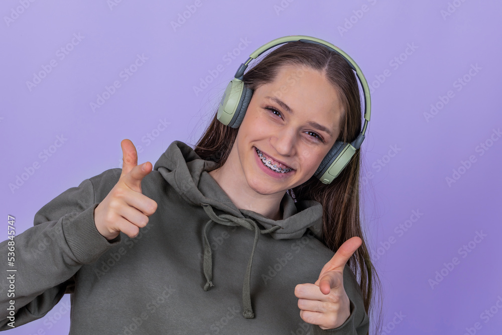 laughing young girl with braces in headphones