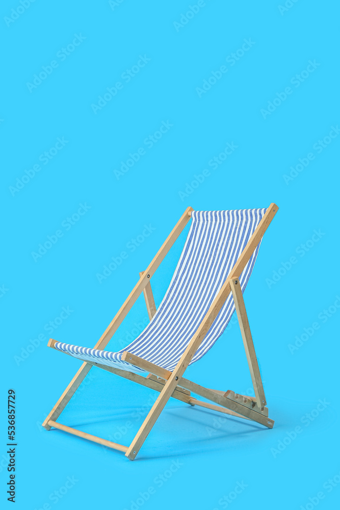 Beach deck chair on light blue background