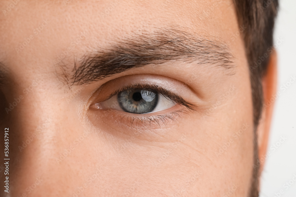 Man with blue eyes on white background, closeup