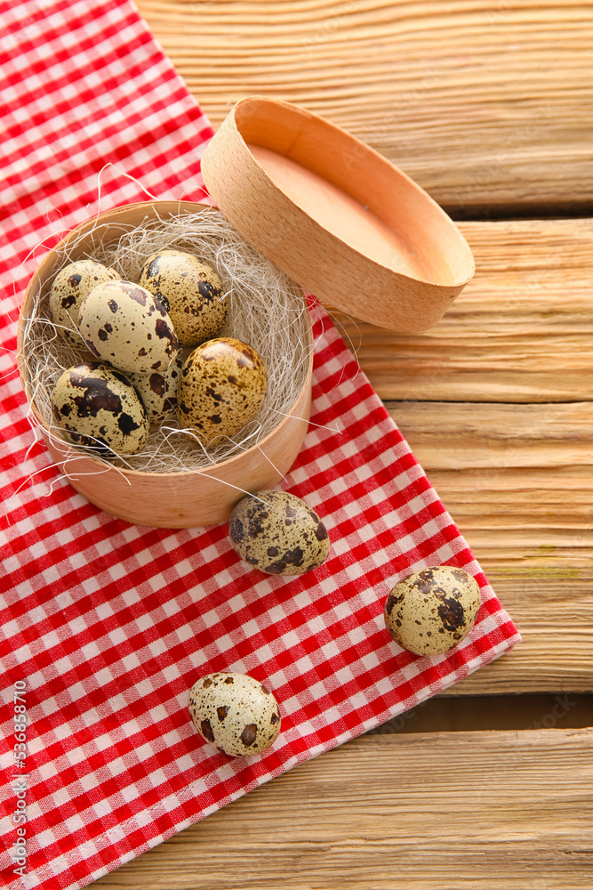 Box with fresh quail eggs on wooden table