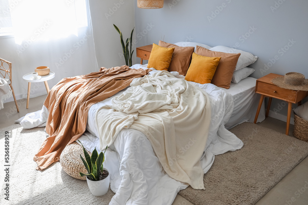 Interior of modern room with big bed and houseplants