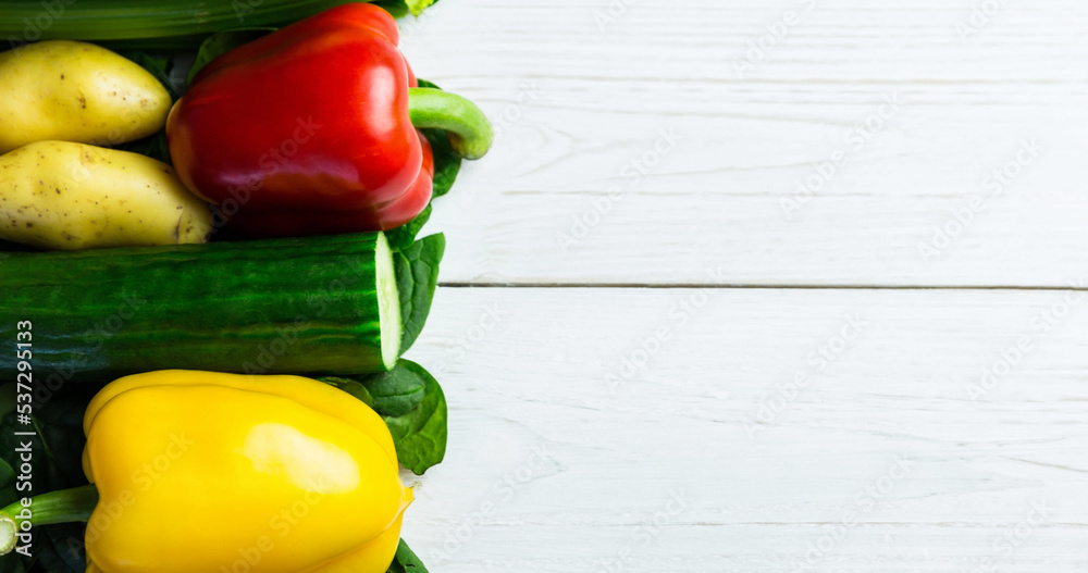 Overhead view of bell pepper, potatoes, celery and cucumbers arranged on wooden table, copy space