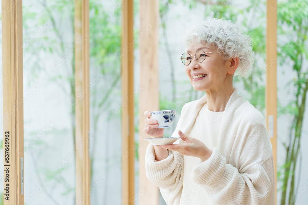 リビングでお茶を飲むシニア女性