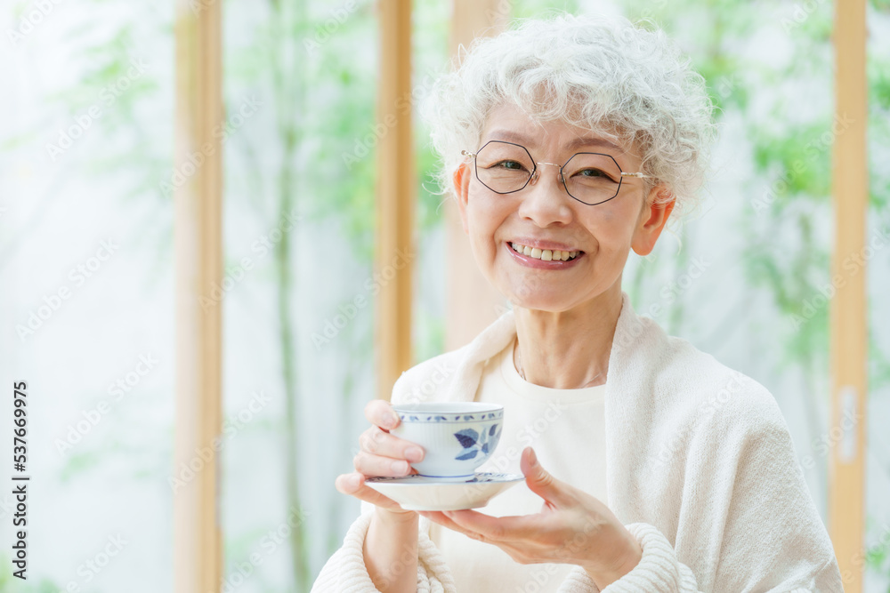 リビングでお茶を飲むシニア女性