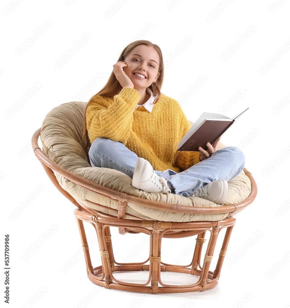 Young woman with book sitting in armchair on white background