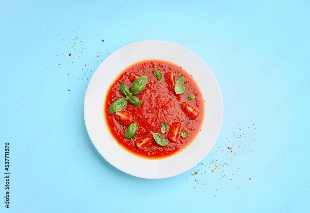 Plate of tasty tomato soup on color background