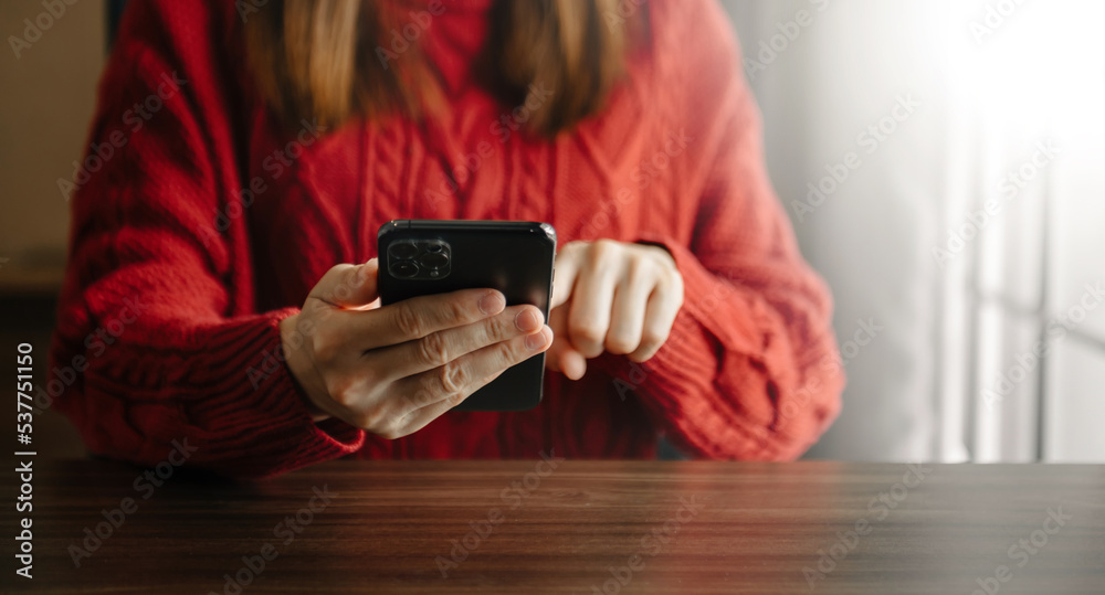 年轻女子在办公室打字智能手机的手特写