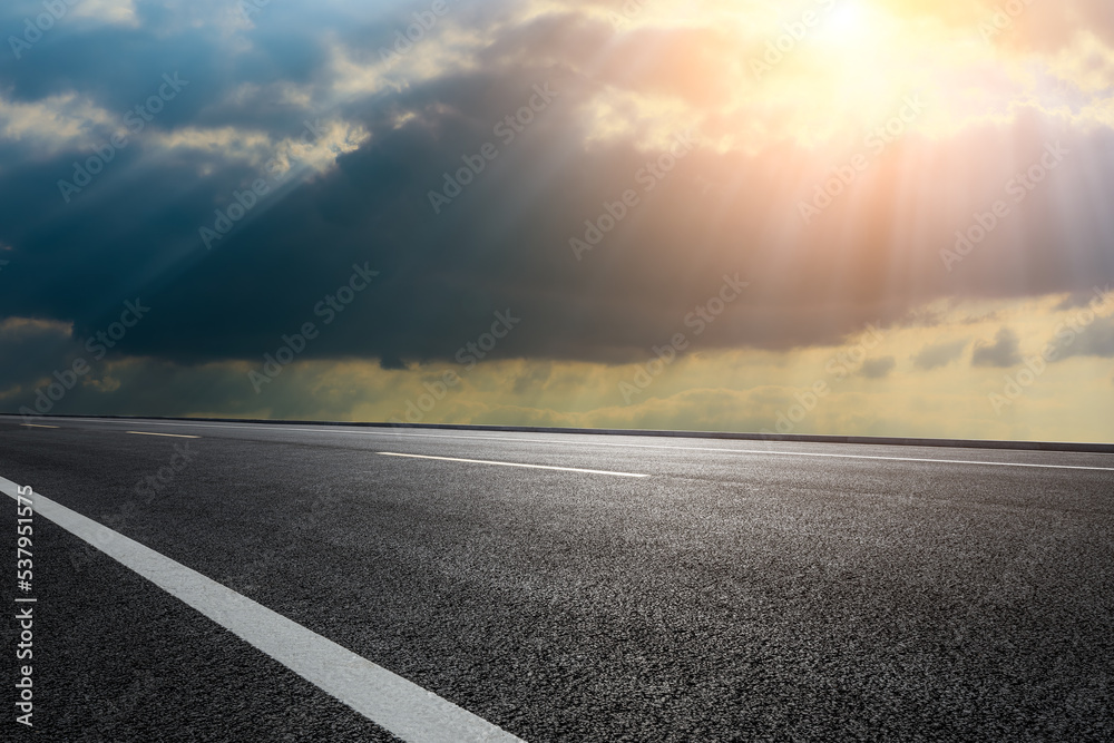 日出时的柏油路和天空云朵。道路和天空背景。