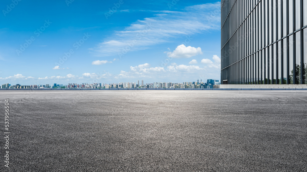 Asphalt road ground and city skyline with modern commercial building in Suzhou, China.