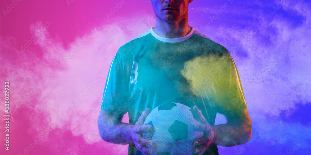 Midsection of caucasian male player holding ball against colorful neon background, copy space