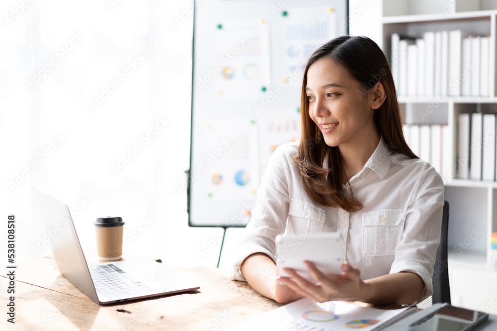 Cheerful business lady working on laptop in office, Asian happy beautiful businesswoman in formal su