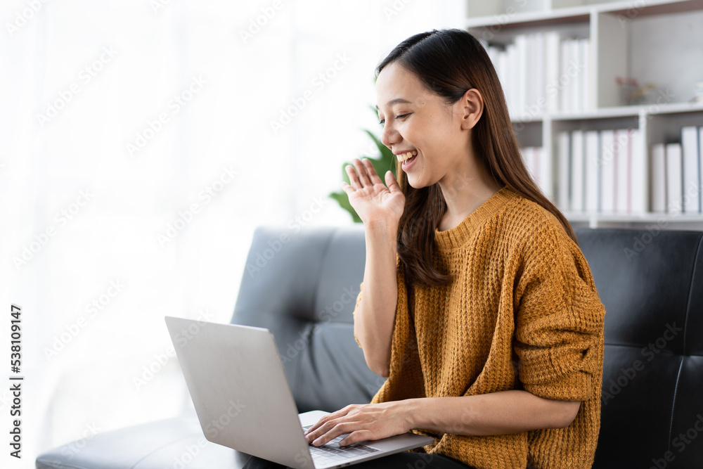 年轻的亚洲女性在家使用笔记本电脑。在家工作，视频会议，在线会议视频通话。