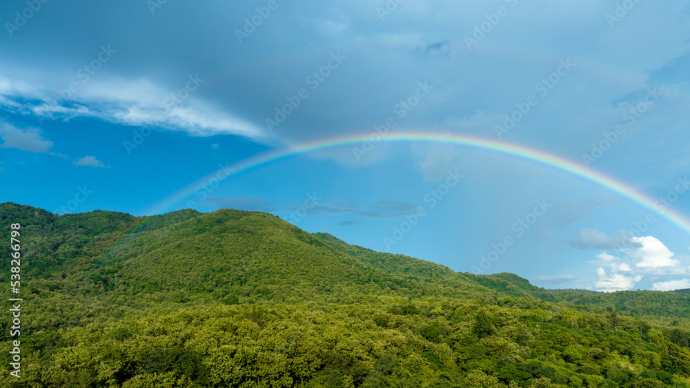 山上天空中的彩虹，在大自然中飞行的全景，雨中的彩虹，鸟瞰图