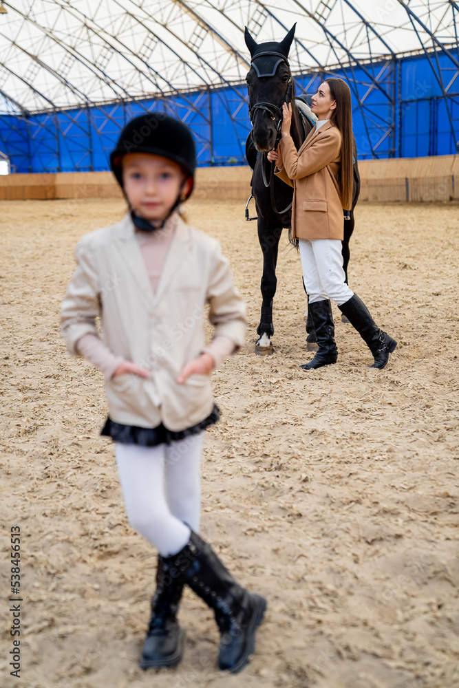 乡下骑马的漂亮小女孩。穿着骑师制服的小孩。