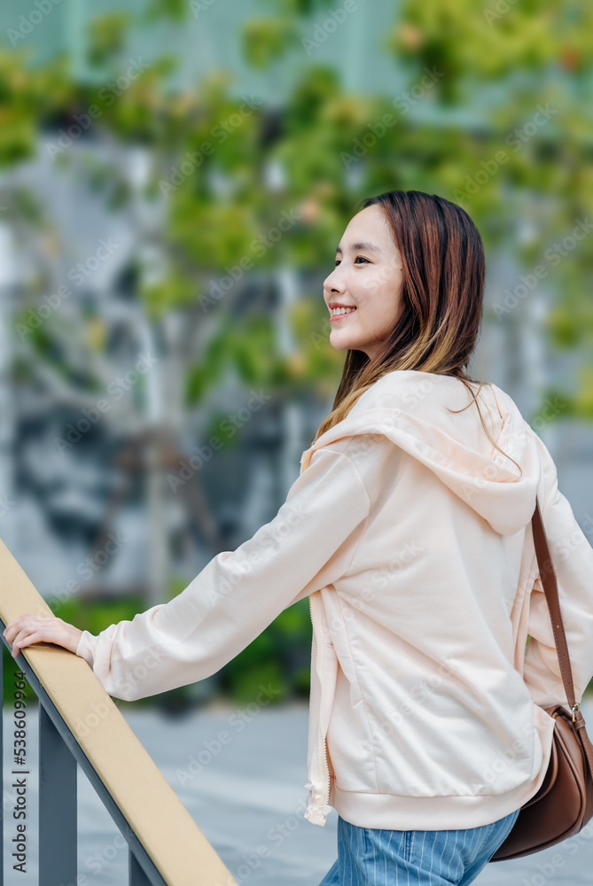 美丽的亚洲女人用手机耳机听最喜欢的音乐，幸福放松