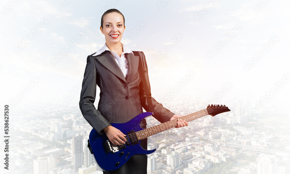 Young businesswoman with electric guitar