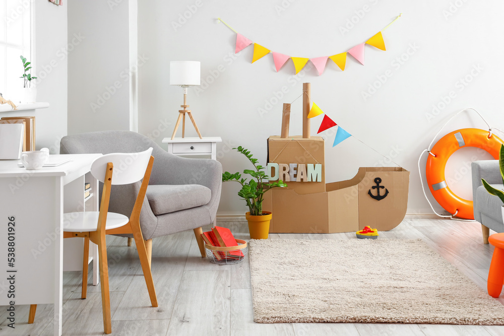 Interior of childrens room with toy cardboard ship