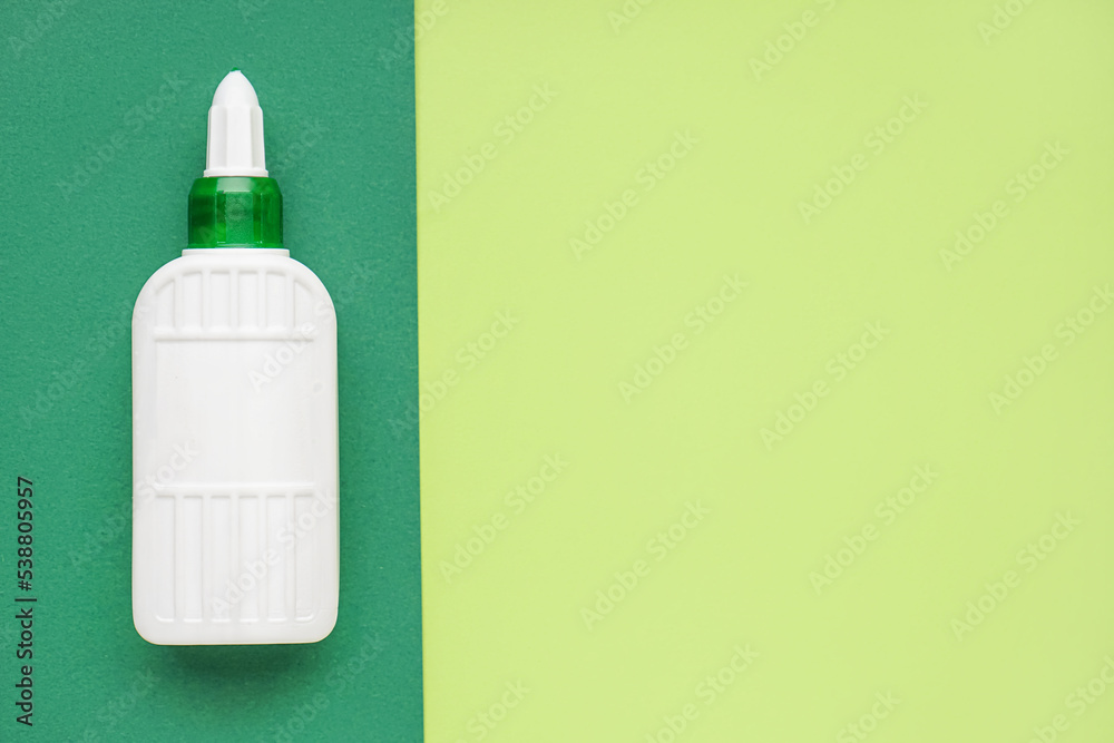 Bottle of glue on green background