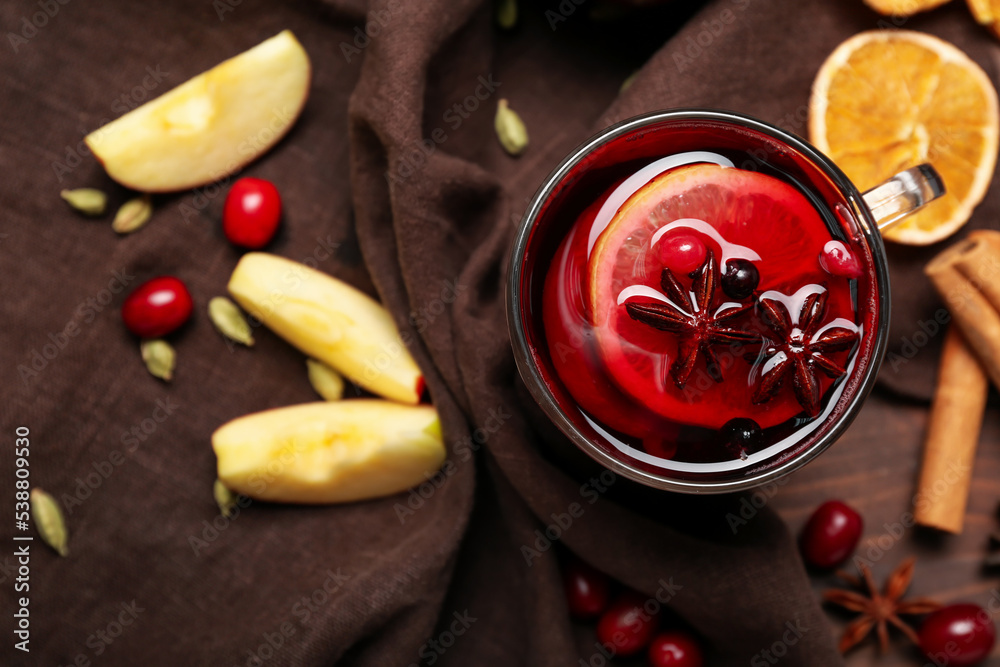 Cup of aromatic mulled wine on table