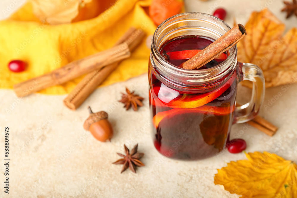 Mason jar of tasty mulled wine on light background