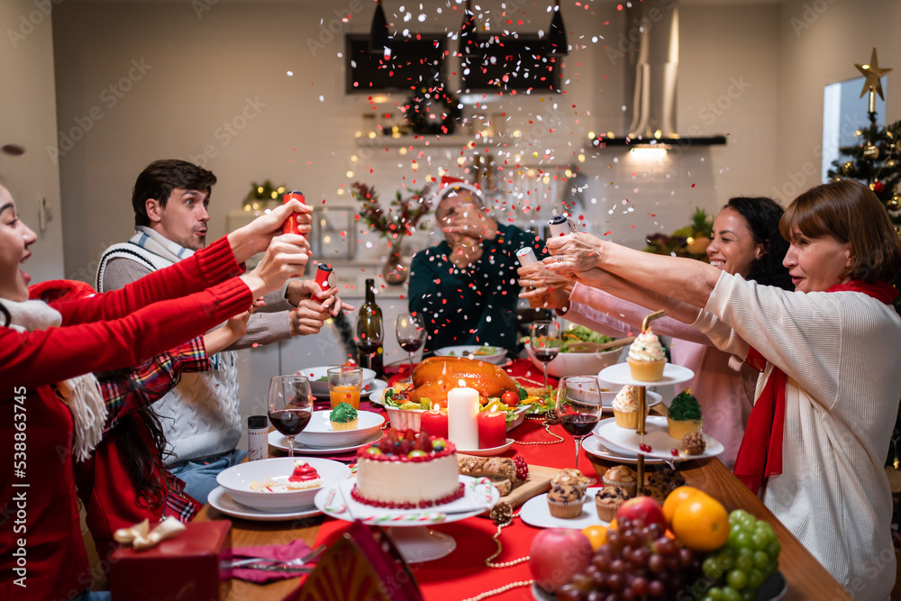 Multi-ethnic big family celebrating Christmas party together in house.