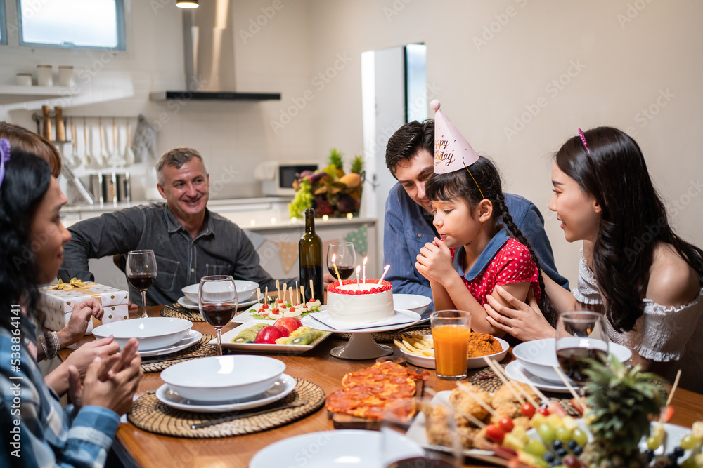 Multi-ethnic big family having a birthday party for young kid daughter