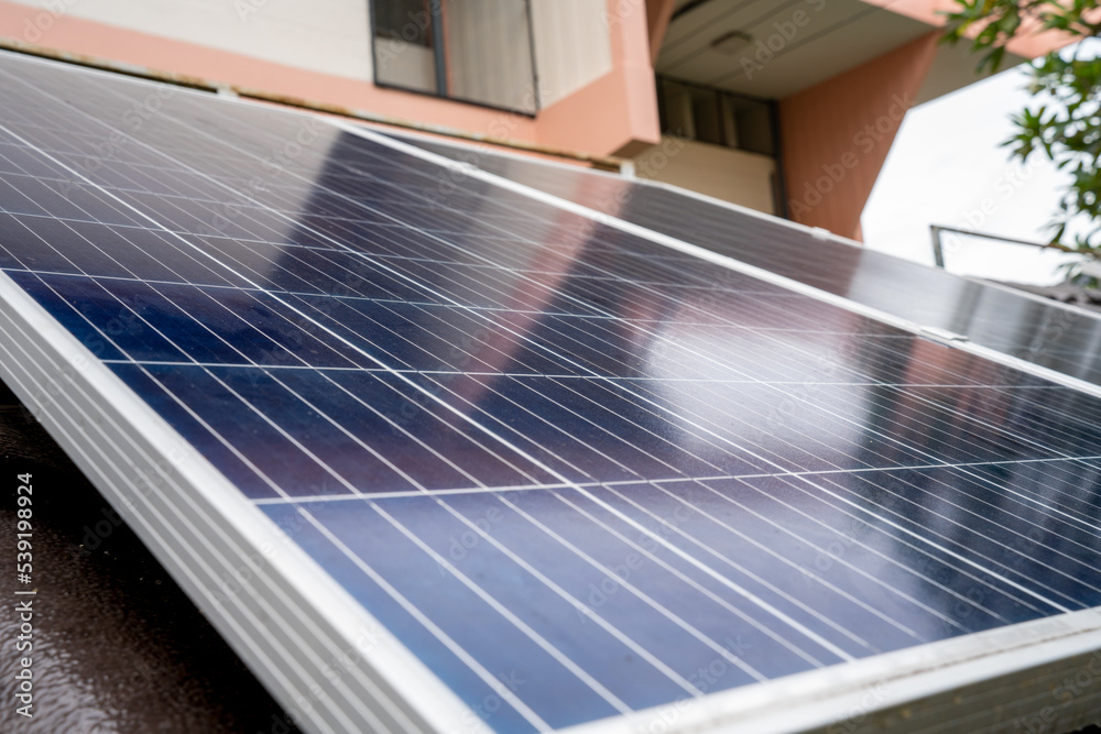 Blue Solar Photo voltaic panels system of apartment building on sunny day. Renewable ecological gree