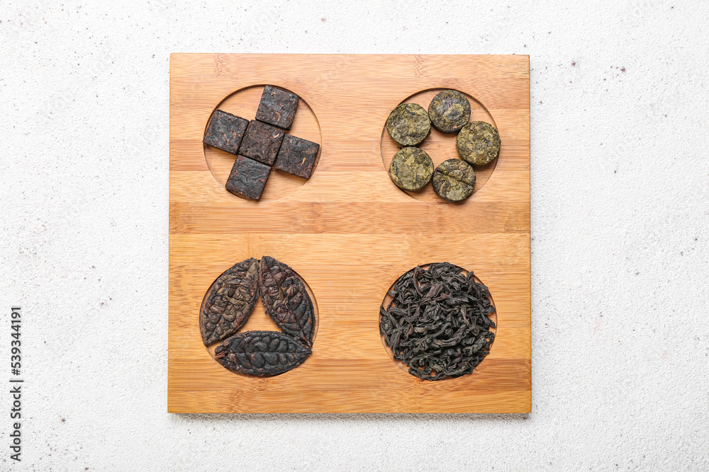 Board with dry pressed puer tea on white background