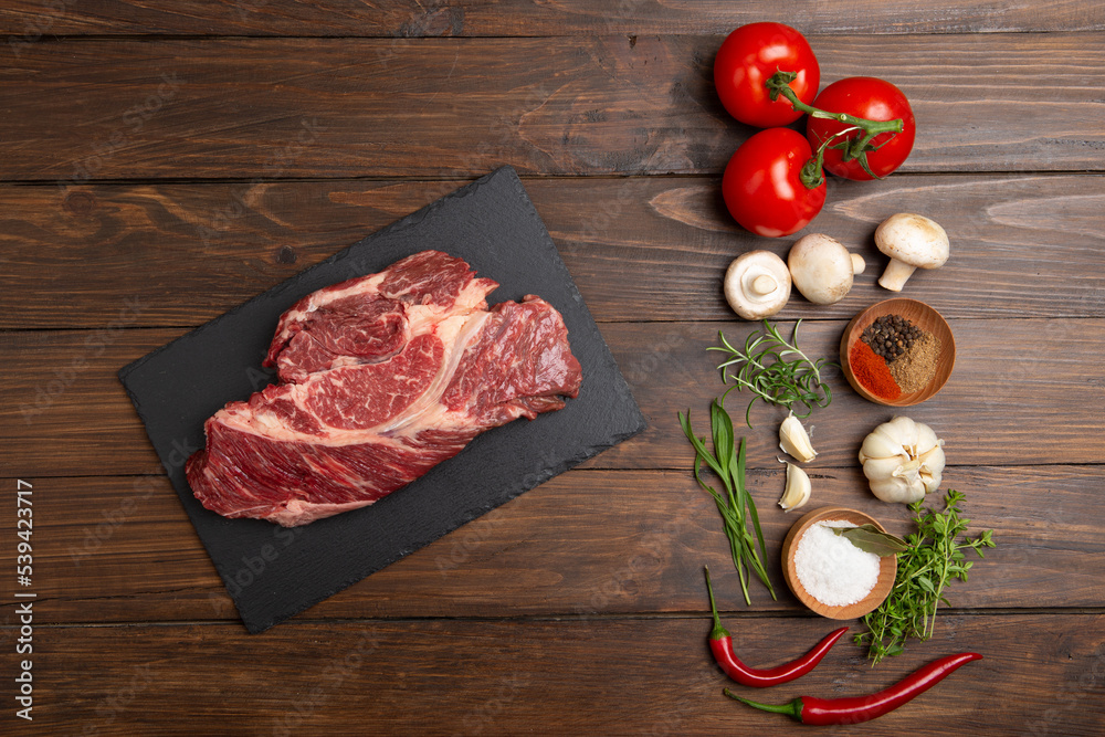 Raw beef steak on wooden table top. Healthy food concept. beef cut and spices for cooking bbq sauce