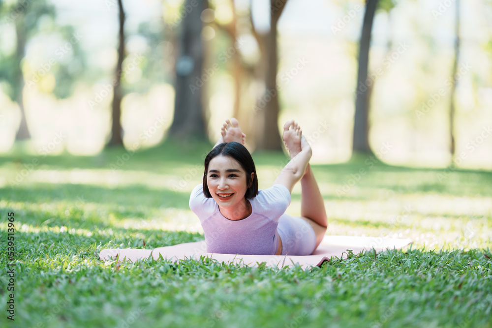 Beautiful young asian woman yoga exercising in the park.