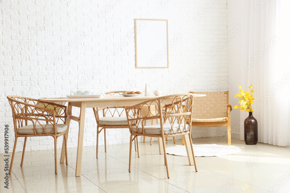 Interior of dining room with modern furniture near white brick wall