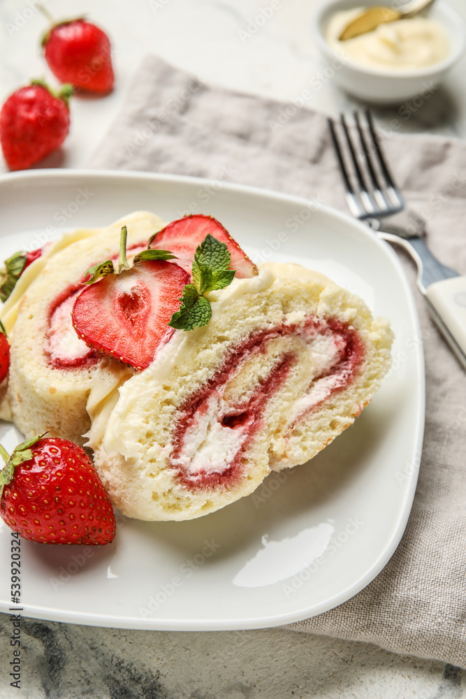 Plate with slices of sweet strawberry roll cake on table, closeup