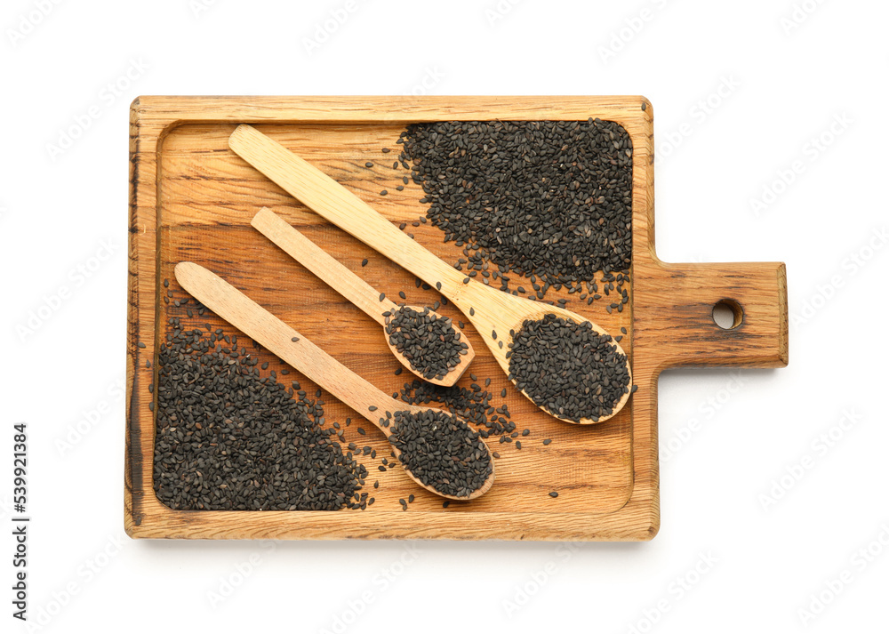 Wooden board with spoons of black sesame seeds isolated on white background