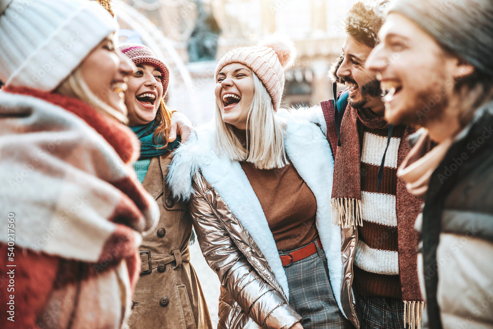 Happy group of friends wearing winter clothes having fun walking on city street - Young people talki