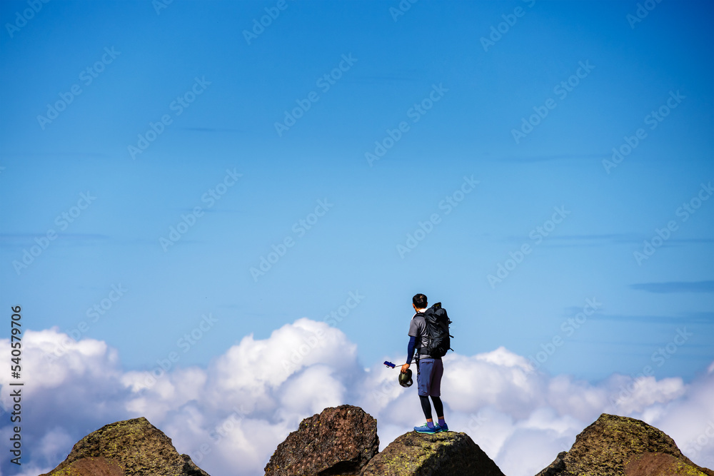 青空と雲と石だらけの登山道