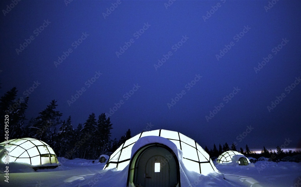 夜晚雪地里的玻璃冰屋。观看北极光的玻璃屋。芬兰