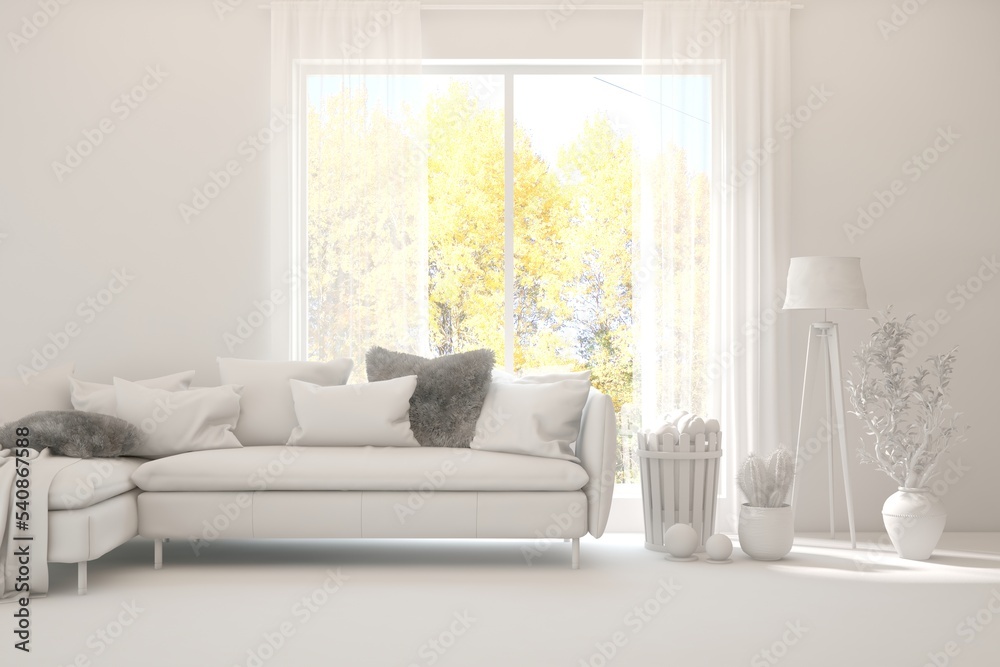 Stylish room in white color with sofa and autumn landscape in window. Scandinavian interior design. 