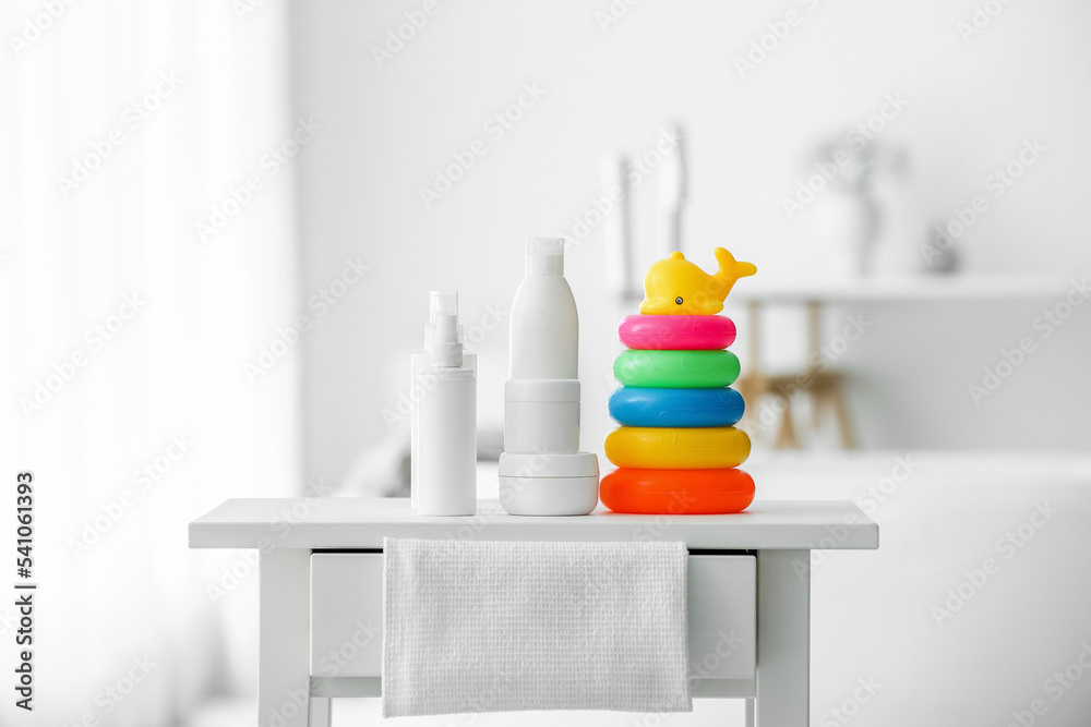 Bath accessories for children and cute toys on white table in light bathroom