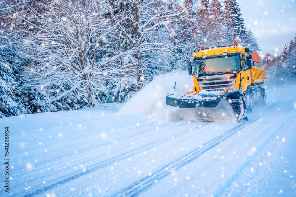 扫雪卡车在暴风雪中清理道路。