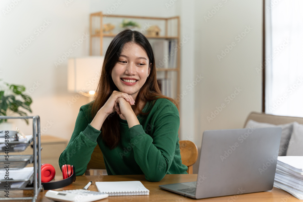 桌上有笔记本电脑的亚洲女孩。